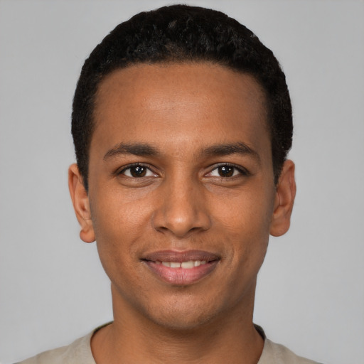 Joyful black young-adult male with short  black hair and brown eyes
