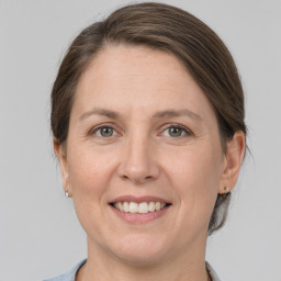 Joyful white adult female with medium  brown hair and grey eyes