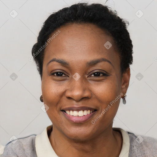 Joyful black young-adult female with short  black hair and brown eyes