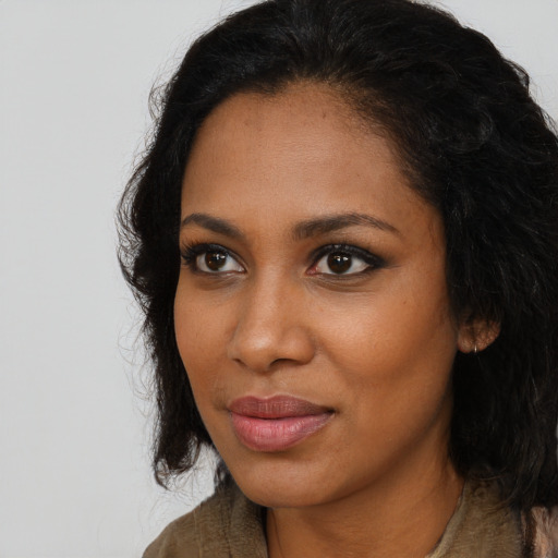 Joyful black young-adult female with long  brown hair and brown eyes