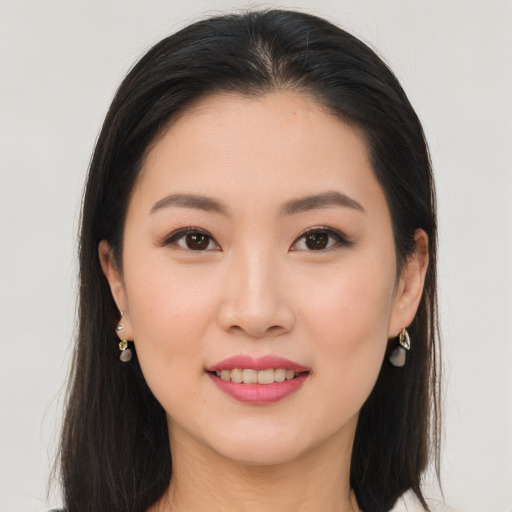 Joyful asian young-adult female with long  brown hair and brown eyes