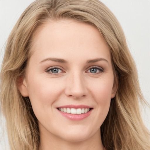 Joyful white young-adult female with long  brown hair and blue eyes