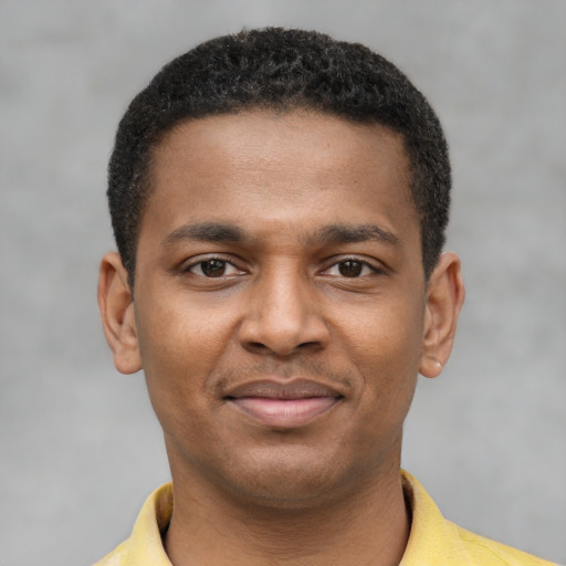 Joyful black young-adult male with short  brown hair and brown eyes