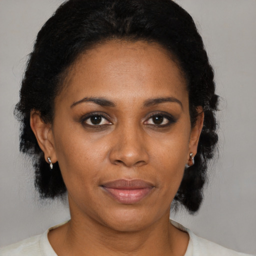 Joyful black adult female with medium  black hair and brown eyes