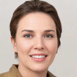 Joyful white young-adult female with medium  brown hair and grey eyes