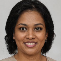 Joyful black adult female with medium  brown hair and brown eyes