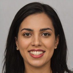 Joyful latino young-adult female with long  brown hair and brown eyes