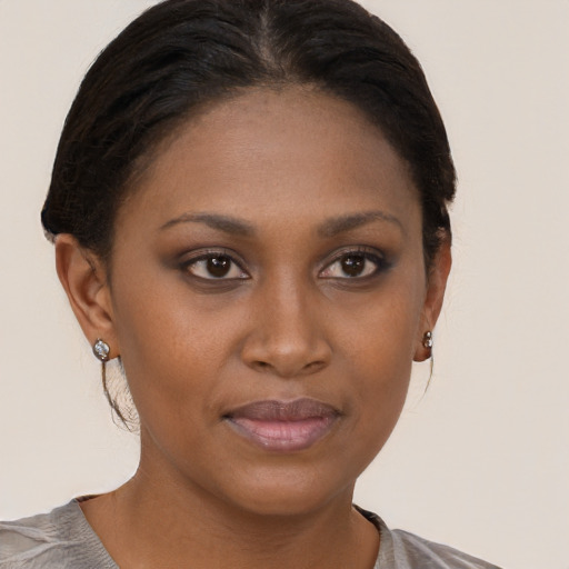 Joyful black young-adult female with short  brown hair and brown eyes