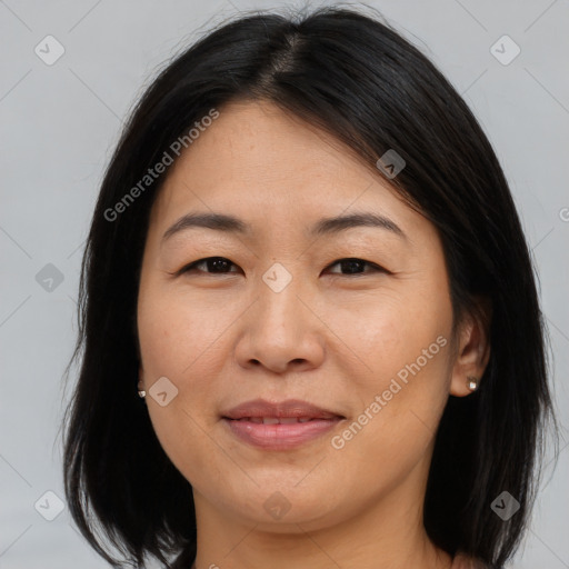 Joyful asian adult female with medium  brown hair and brown eyes