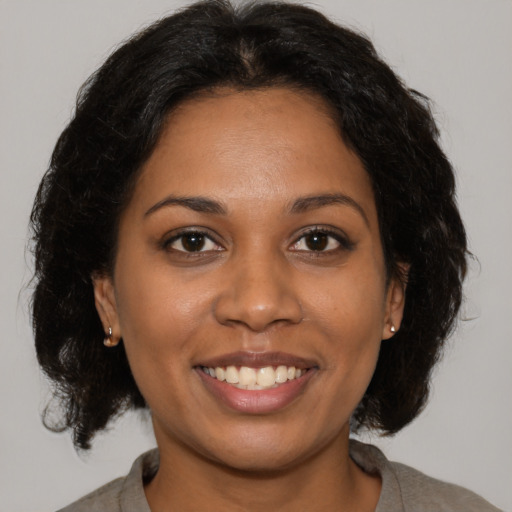 Joyful black young-adult female with medium  brown hair and brown eyes