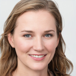 Joyful white young-adult female with long  brown hair and blue eyes