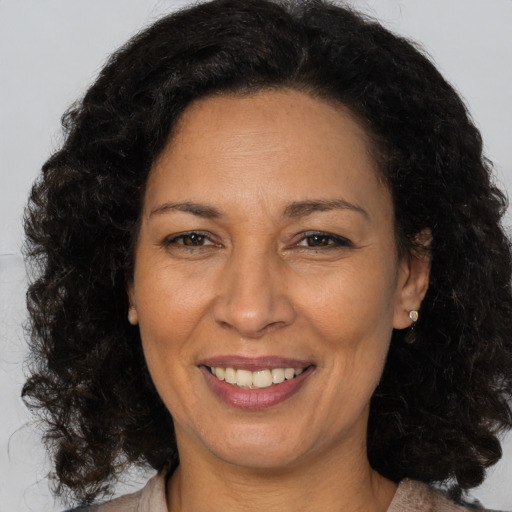 Joyful latino adult female with medium  brown hair and brown eyes