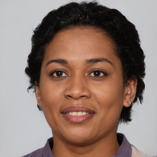 Joyful black young-adult female with short  black hair and brown eyes