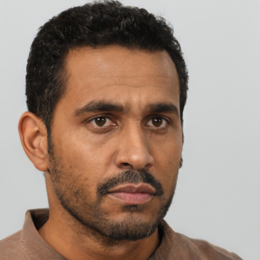 Neutral latino adult male with short  black hair and brown eyes