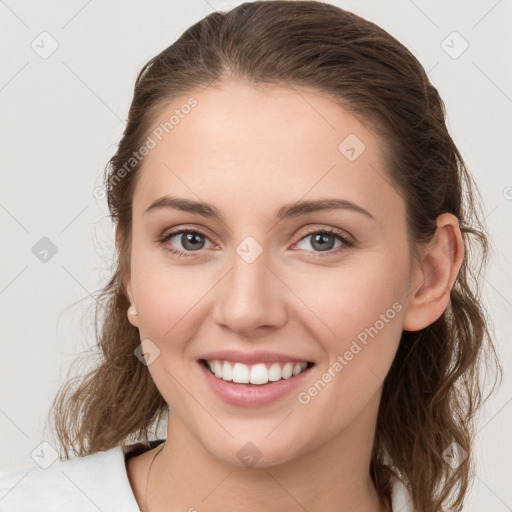 Joyful white young-adult female with medium  brown hair and grey eyes