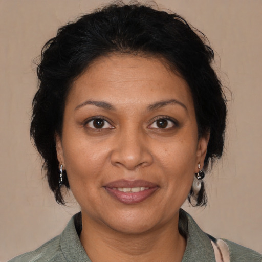 Joyful latino adult female with medium  brown hair and brown eyes