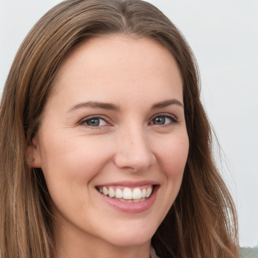 Joyful white young-adult female with long  brown hair and green eyes