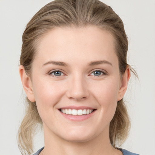 Joyful white young-adult female with medium  brown hair and grey eyes