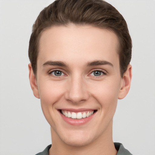 Joyful white young-adult female with short  brown hair and grey eyes