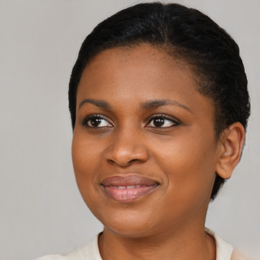 Joyful black young-adult female with short  black hair and brown eyes