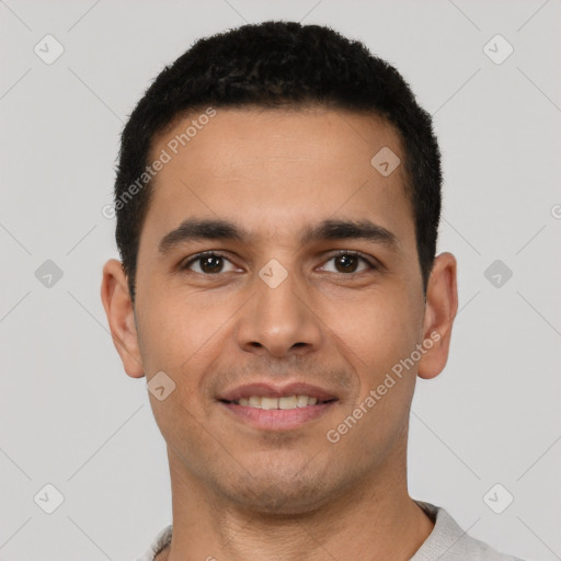 Joyful latino young-adult male with short  black hair and brown eyes