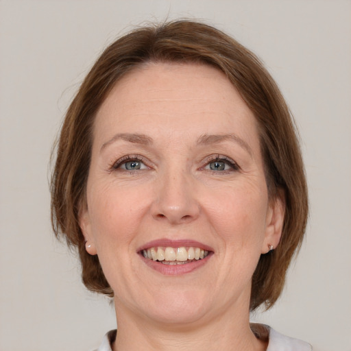 Joyful white adult female with medium  brown hair and grey eyes