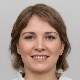 Joyful white young-adult female with medium  brown hair and grey eyes