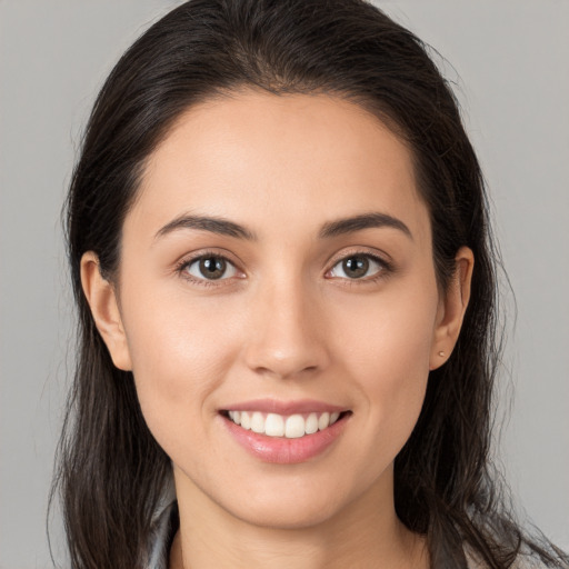 Joyful white young-adult female with long  brown hair and brown eyes