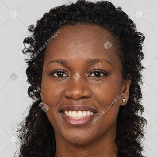 Joyful black young-adult female with long  brown hair and brown eyes