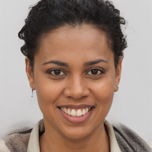 Joyful black young-adult female with short  brown hair and brown eyes