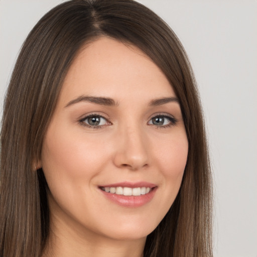 Joyful white young-adult female with long  brown hair and brown eyes