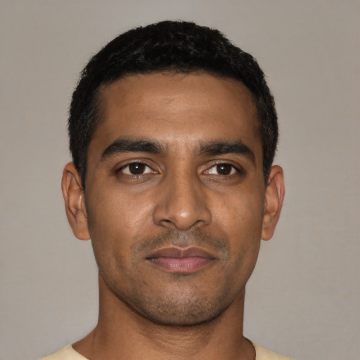 Joyful black young-adult male with short  black hair and brown eyes