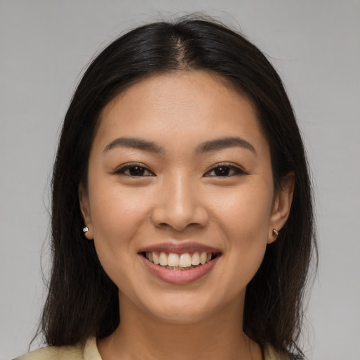 Joyful latino young-adult female with long  brown hair and brown eyes