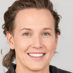 Joyful white adult female with medium  brown hair and grey eyes