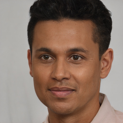 Joyful latino young-adult male with short  brown hair and brown eyes