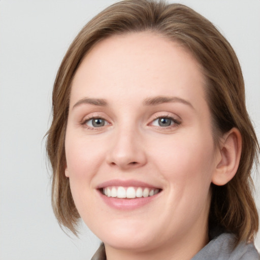 Joyful white young-adult female with medium  brown hair and blue eyes