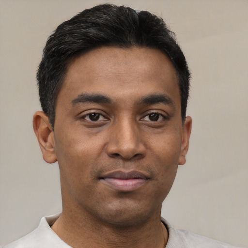 Joyful latino young-adult male with short  brown hair and brown eyes