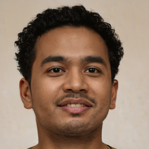 Joyful latino young-adult male with short  brown hair and brown eyes