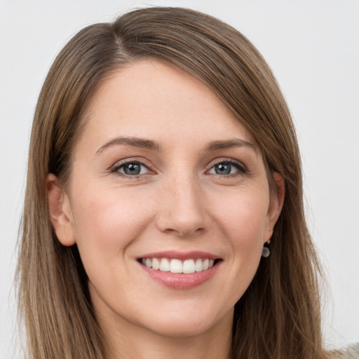 Joyful white young-adult female with long  brown hair and grey eyes