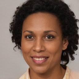 Joyful black adult female with medium  brown hair and brown eyes