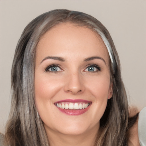 Joyful white young-adult female with long  brown hair and blue eyes