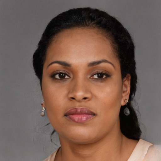 Joyful black young-adult female with long  black hair and brown eyes
