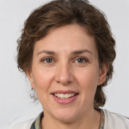 Joyful white adult female with medium  brown hair and grey eyes