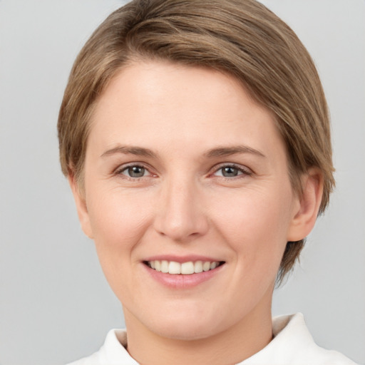 Joyful white young-adult female with short  brown hair and grey eyes