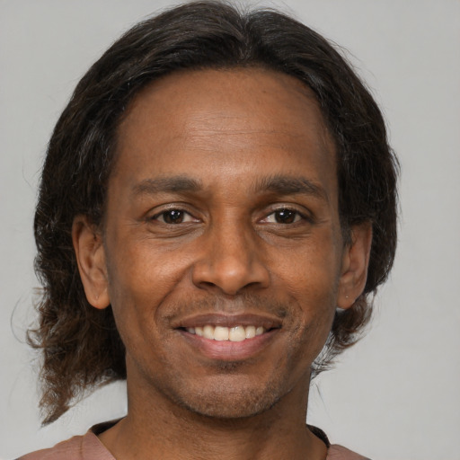 Joyful black adult male with medium  brown hair and brown eyes