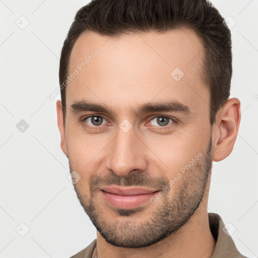 Joyful white young-adult male with short  brown hair and brown eyes