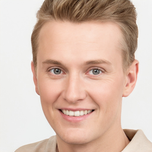 Joyful white young-adult male with short  brown hair and grey eyes