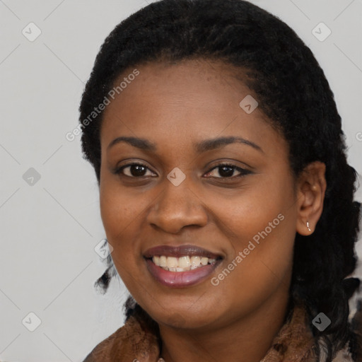 Joyful black young-adult female with long  black hair and brown eyes