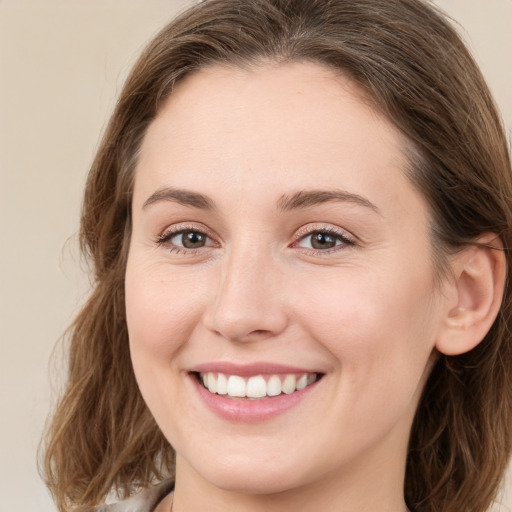 Joyful white young-adult female with long  brown hair and green eyes