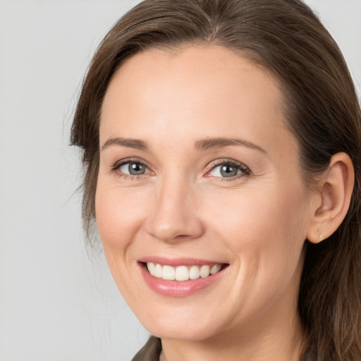 Joyful white young-adult female with long  brown hair and grey eyes